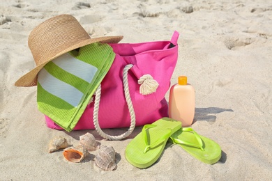 Set of different stylish beach accessories on sand