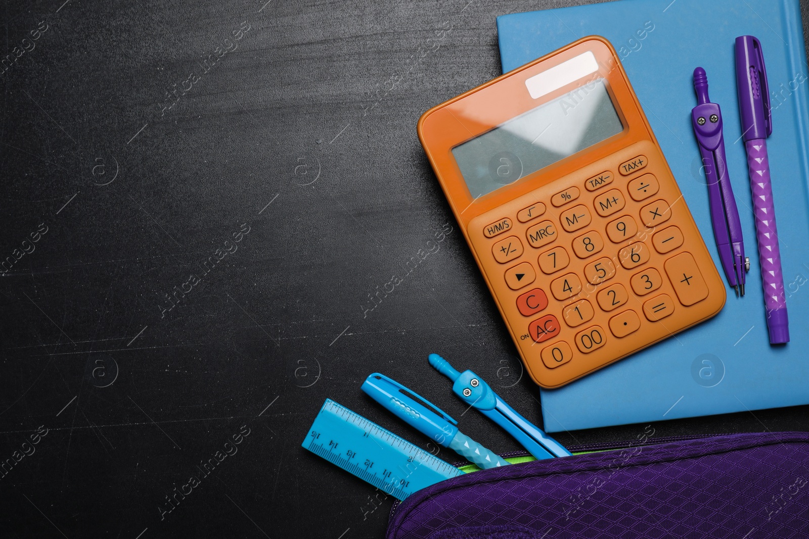 Photo of Flat lay composition with school stationery on blackboard, space for text