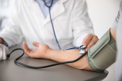 Doctor measuring patient's blood pressure in hospital