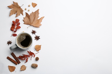 Flat lay composition with cup of hot drink and autumn leaves on white background, space for text. Cozy atmosphere