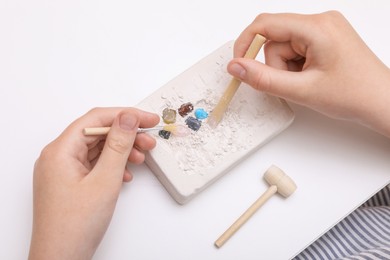 Child playing with Excavation kit at white table, above view. Educational toy for motor skills