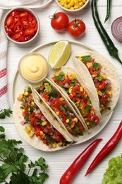 Photo of Tasty tacos with vegetables on white wooden table, flat lay