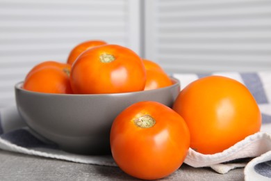 Photo of Many ripe yellow tomatoes on grey table