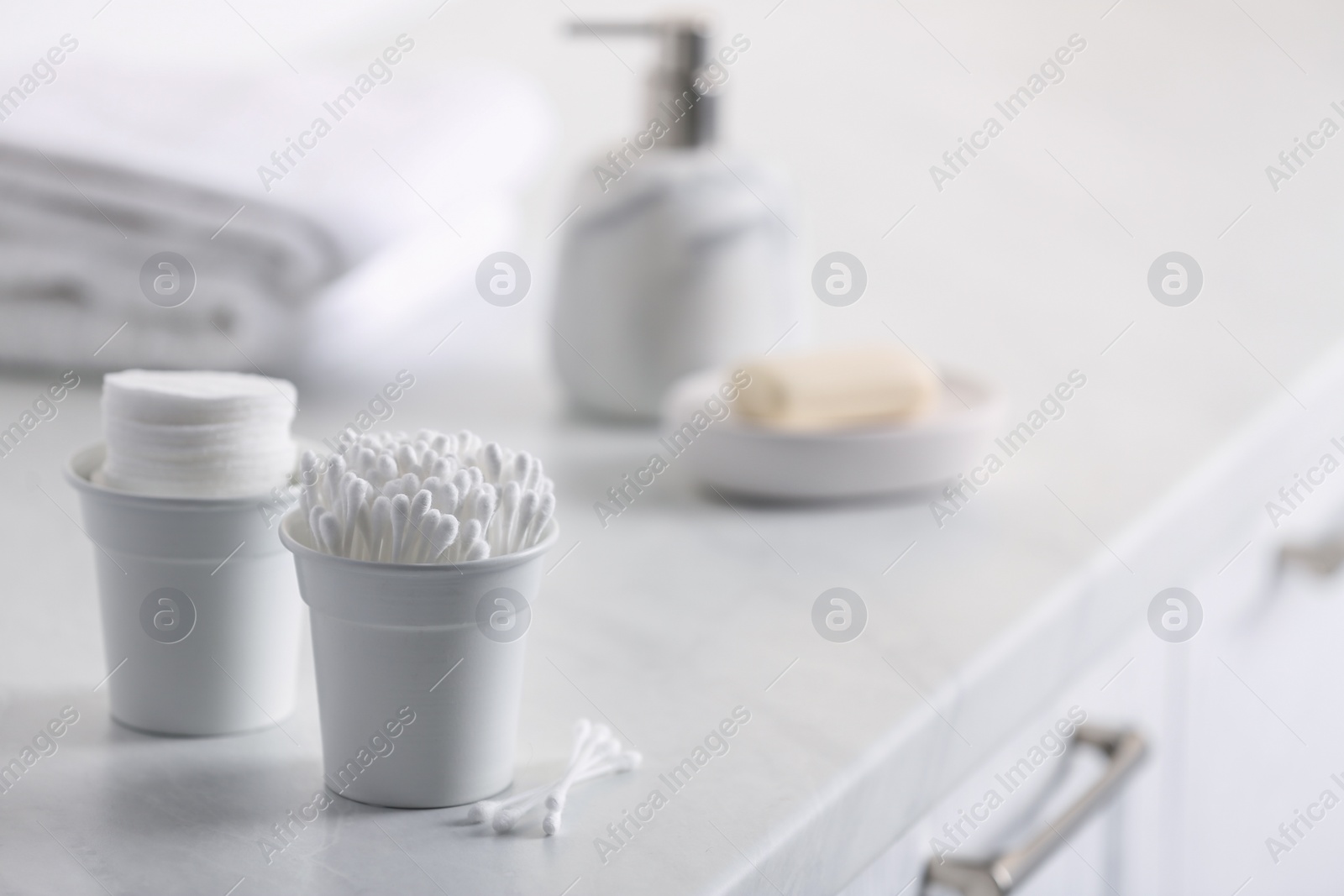 Photo of Cotton buds and pads on white table indoors, space for text