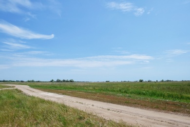 Photo of Countryside road in green field on sunny day