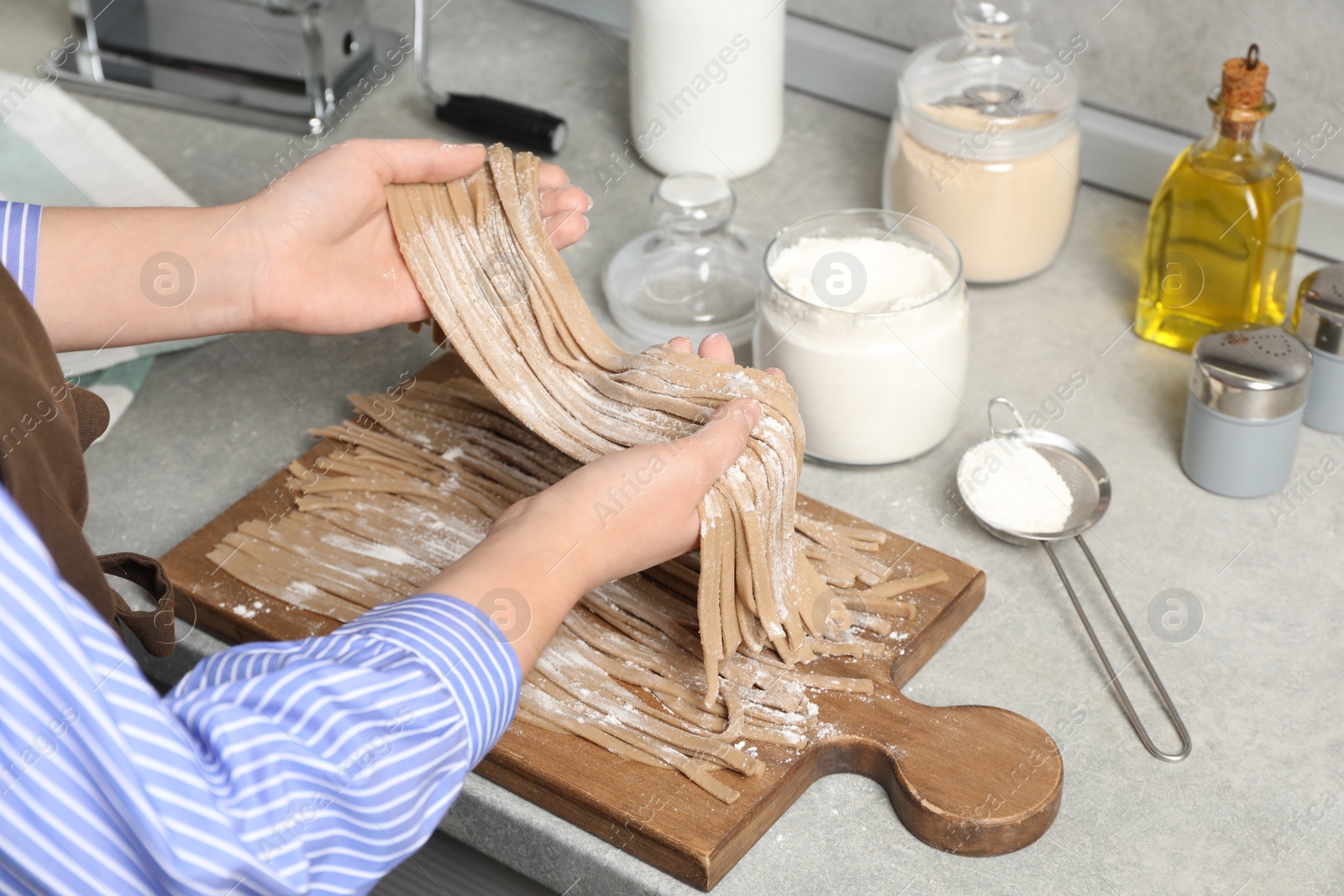 Photo of Woman making soba at table in kitchen, closeup