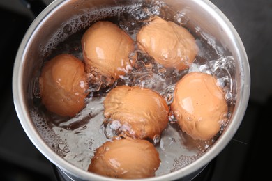 Chicken eggs boiling in saucepan on electric stove, above view