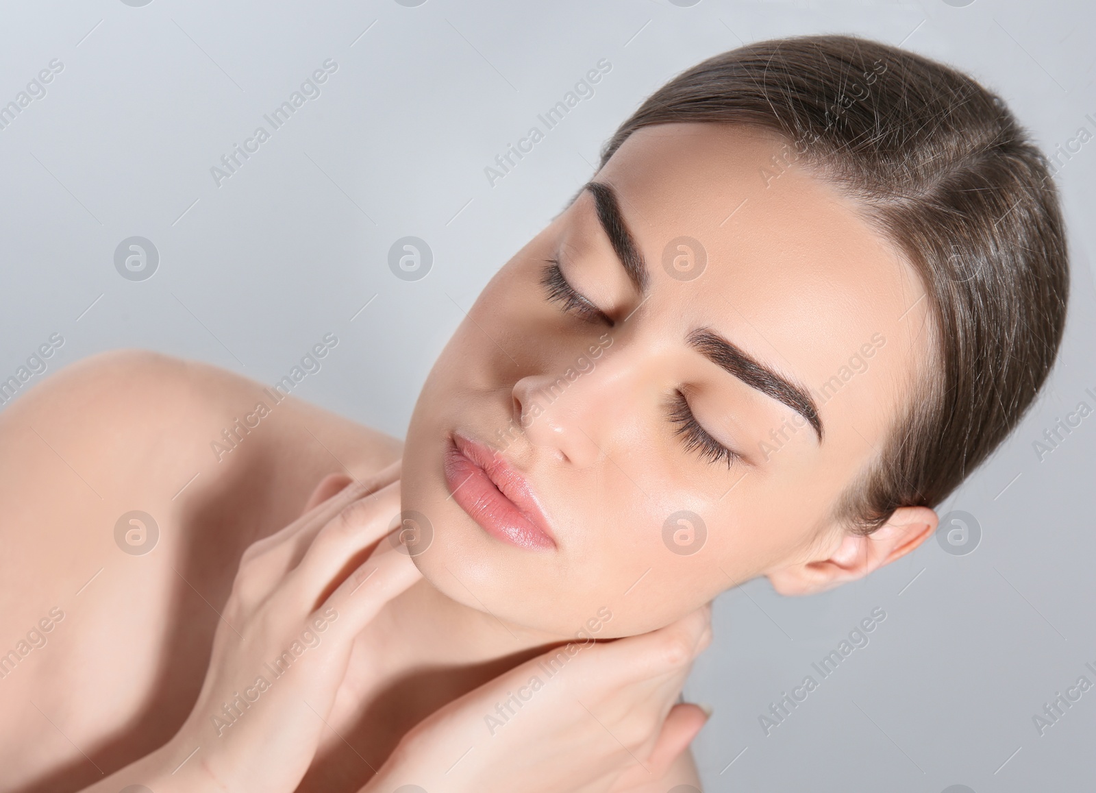 Photo of Beautiful woman with perfect eyebrows on light background