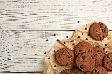 Photo of Delicious chocolate chip cookies on wooden table, flat lay. Space for text