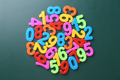 Photo of Colorful numbers on green background, top view