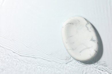 Photo of Presentation of product. Marble podium in water on white background, top view. Space for text