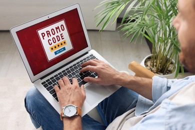 Photo of Man holding laptop with activated promo code indoors, closeup