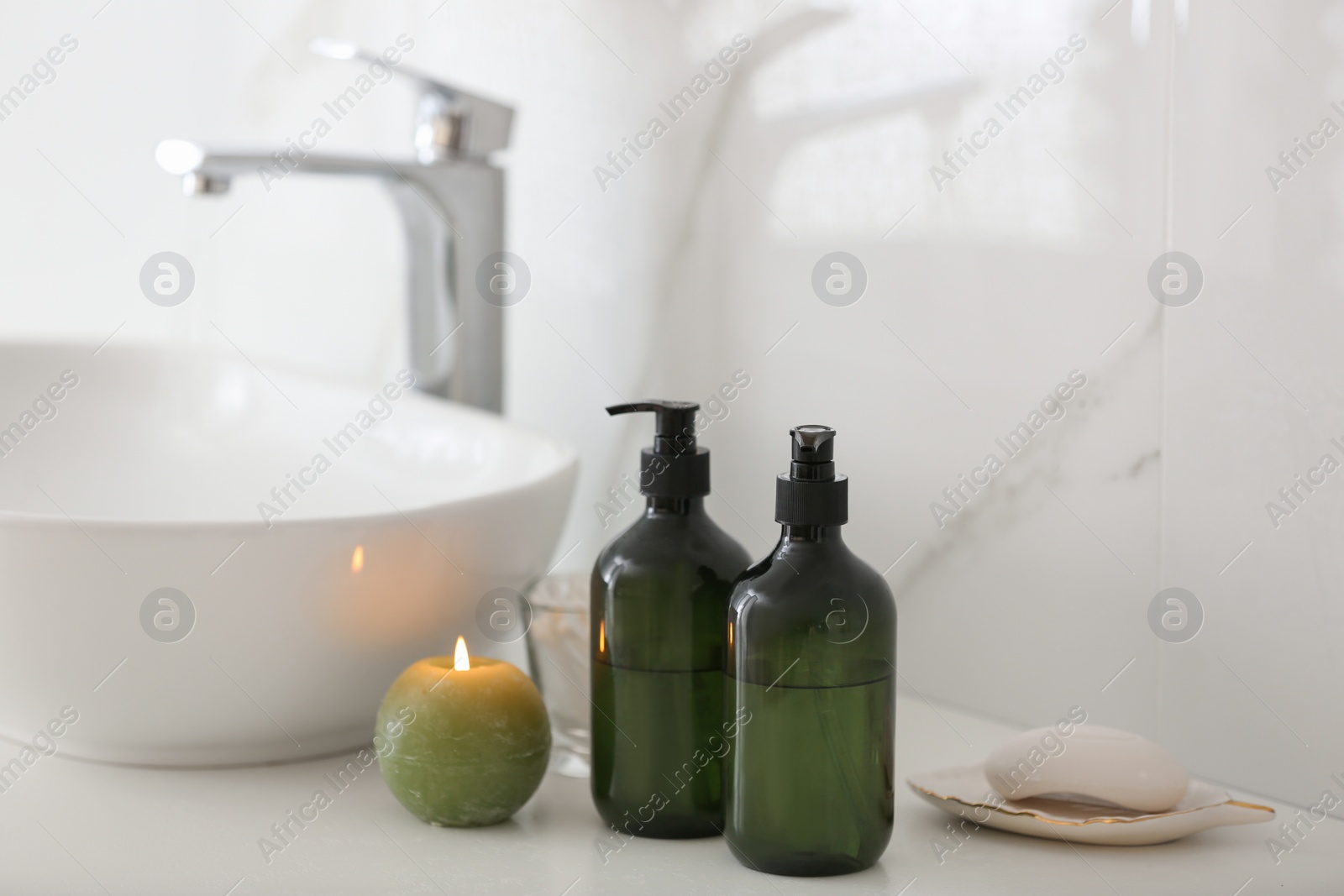 Photo of Green soap dispensers on countertop near sink in bathroom