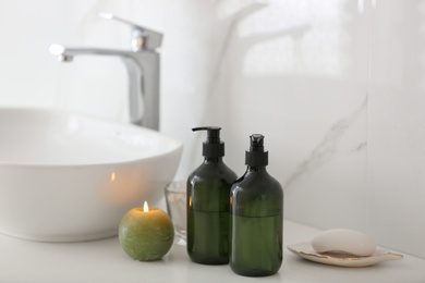 Photo of Green soap dispensers on countertop near sink in bathroom