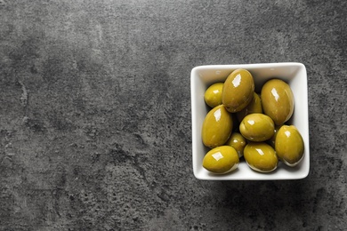 Ripe olives covered with oil in dish on table, top view