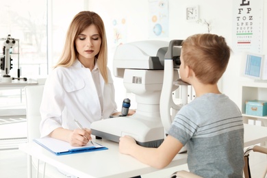 Ophthalmologist examining little boy in clinic