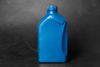 Photo of Motor oil in blue canister on black background