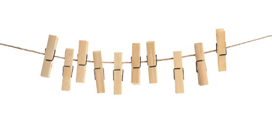 Photo of Many wooden clothespins on rope against white background