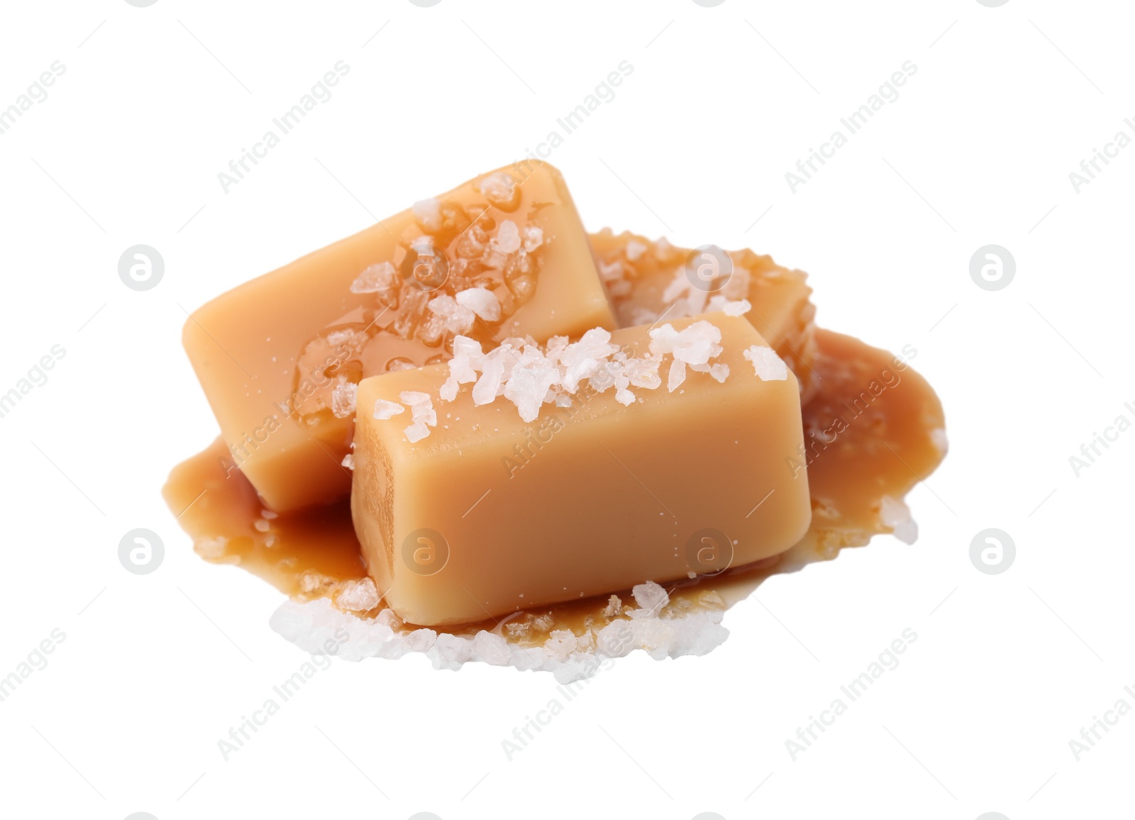 Photo of Yummy caramel candies and sea salt isolated on white