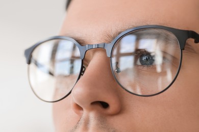 Man wearing glasses on blurred background, closeup