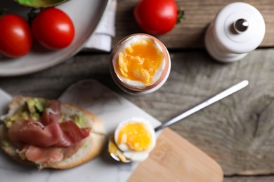 Delicious breakfast with soft boiled egg and sandwich served on wooden table, flat lay