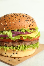 Photo of Burger with delicious patty on light table, closeup