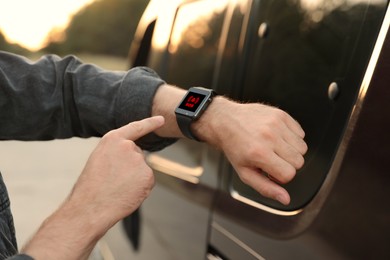 Image of Man using SOS function on smartwatch outdoors, closeup