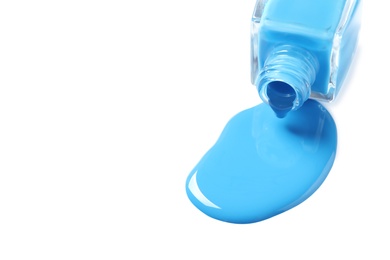 Spilled color nail polish with bottle on white background