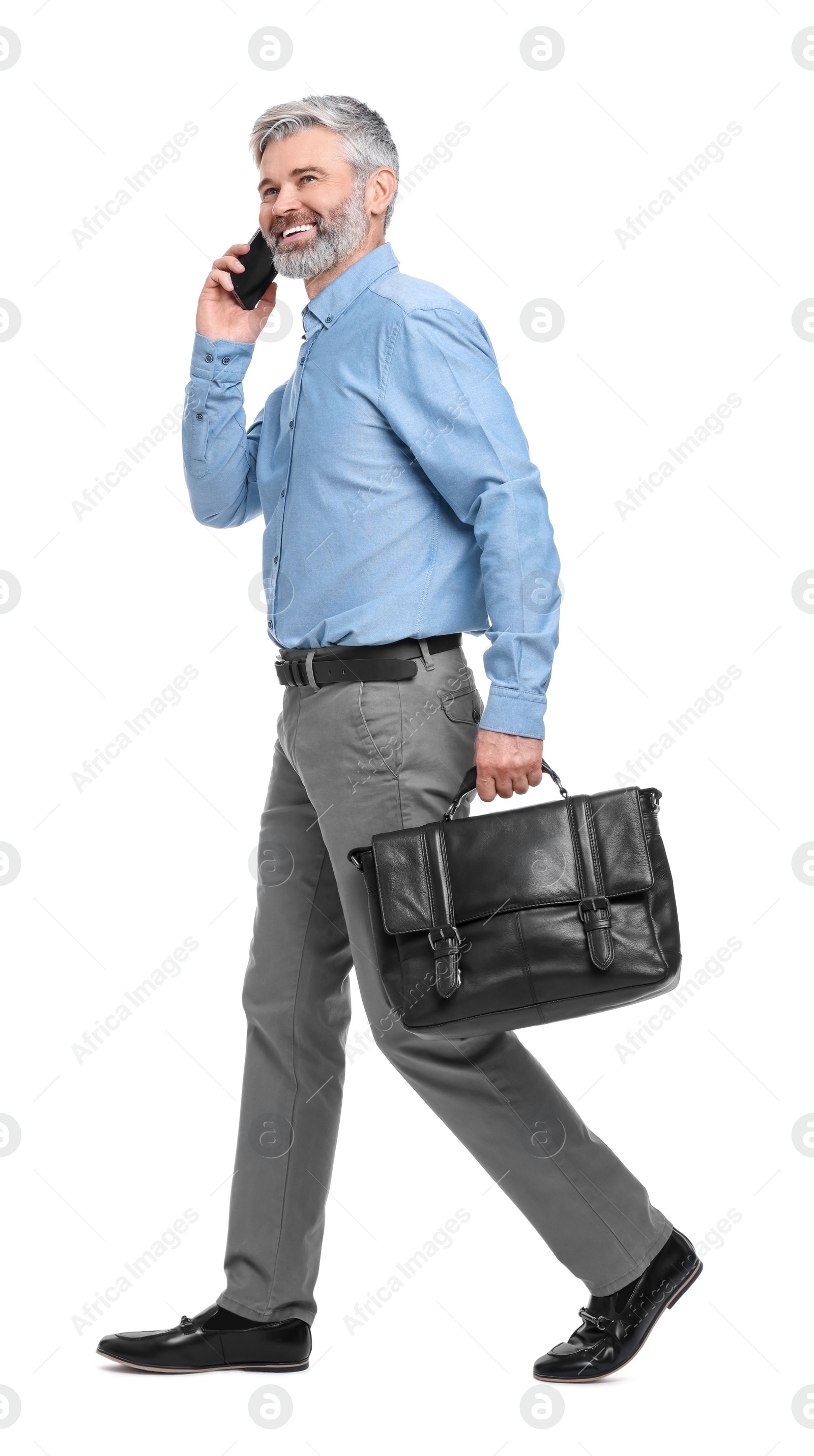 Photo of Mature businessman talking on smartphone against white background