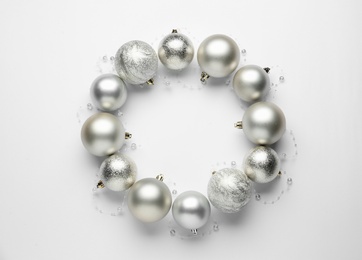 Photo of Beautiful festive wreath made of silver Christmas balls on white background, top view