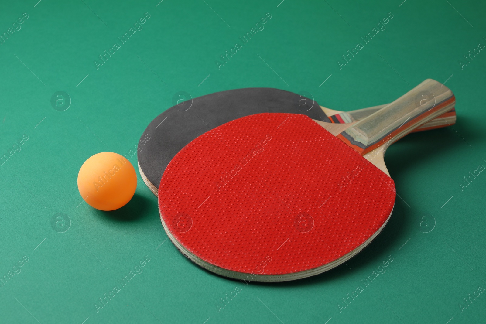 Photo of Ping pong ball and rackets on green background