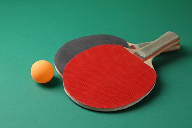 Ping pong ball and rackets on green background