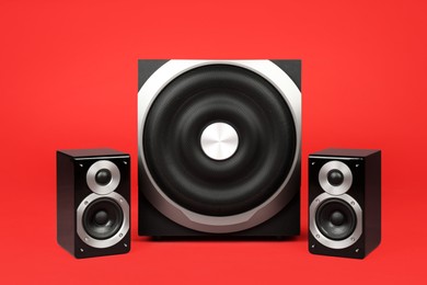 Photo of Modern powerful audio speaker system on red background