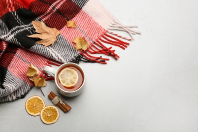 Flat lay composition with tea and warm plaid on light table, space for text