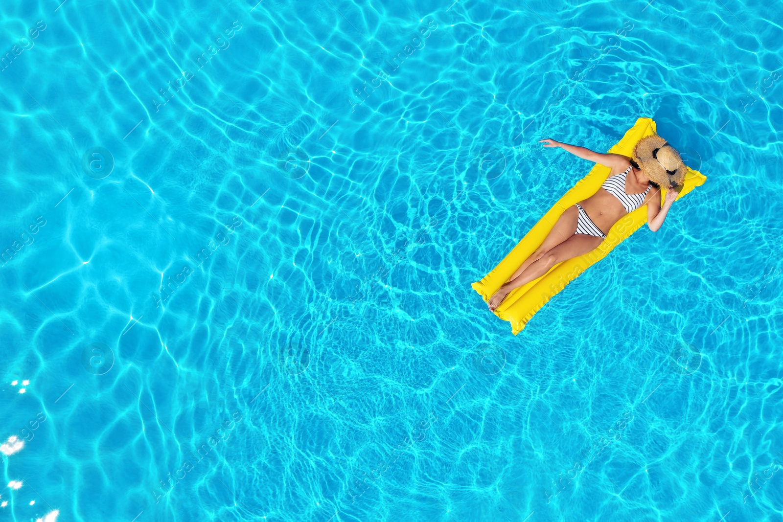 Image of Young woman with inflatable mattress in swimming pool, top view. Space for text