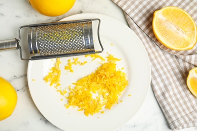 Photo of Lemon zest and fresh fruits on white marble table, flat lay