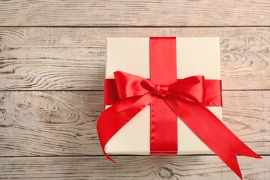 Photo of Elegant gift box with bow on wooden background, top view