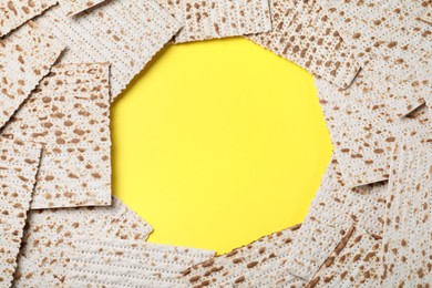 Photo of Frame of traditional matzos on yellow background, flat lay. Space for text