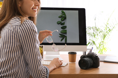 Photo of Professional photographer working at table in office, closeup