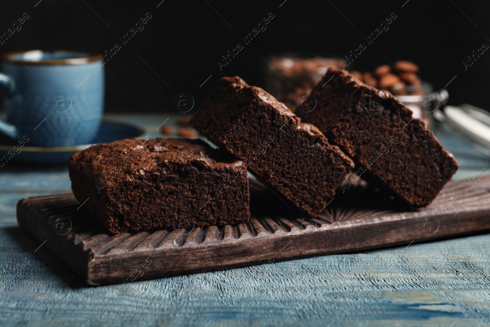 Photo of Wooden board with fresh brownies on table. Delicious chocolate pie