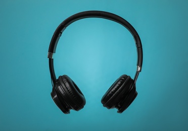 Photo of Wireless headphones with earmuffs on color background