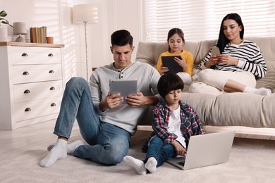 Internet addiction. Family with different gadgets in living room