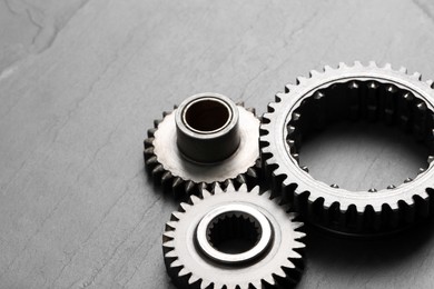 Photo of Different stainless steel gears on grey background, space for text