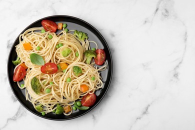 Photo of Plate of delicious pasta primavera on white marble table, top view. Space for text