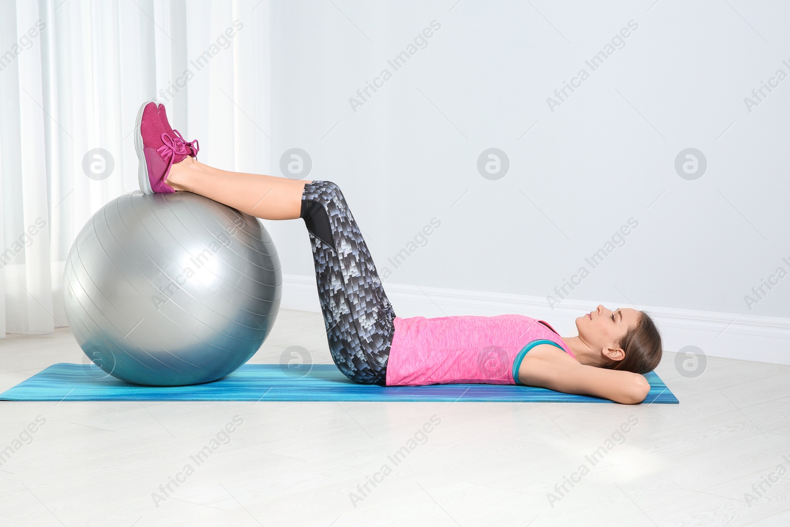 Photo of Young woman doing fitness exercises at home