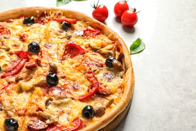 Delicious pizza with olives and sausages on table