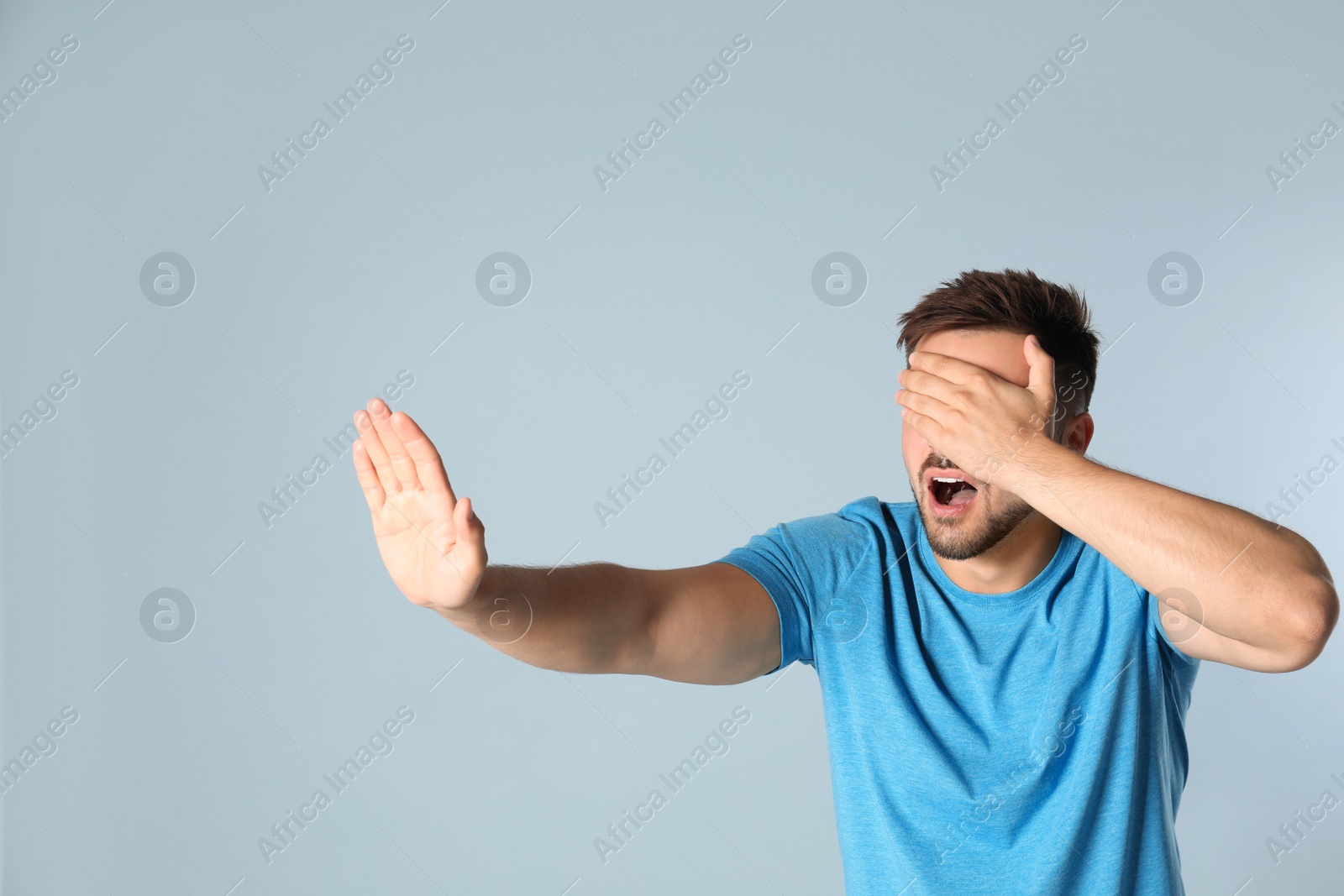 Photo of Young man being blinded on grey background