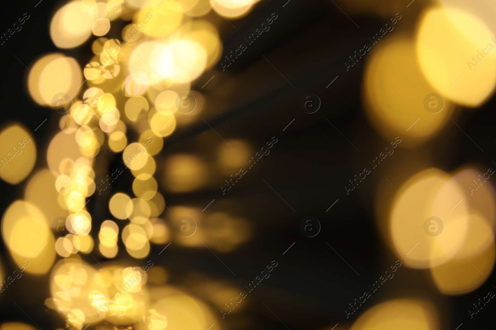 Photo of Golden blurred lights on black background. Bokeh effect