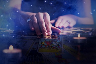 Soothsayer predicting future with tarot cards at table in darkness, closeup. Double exposure