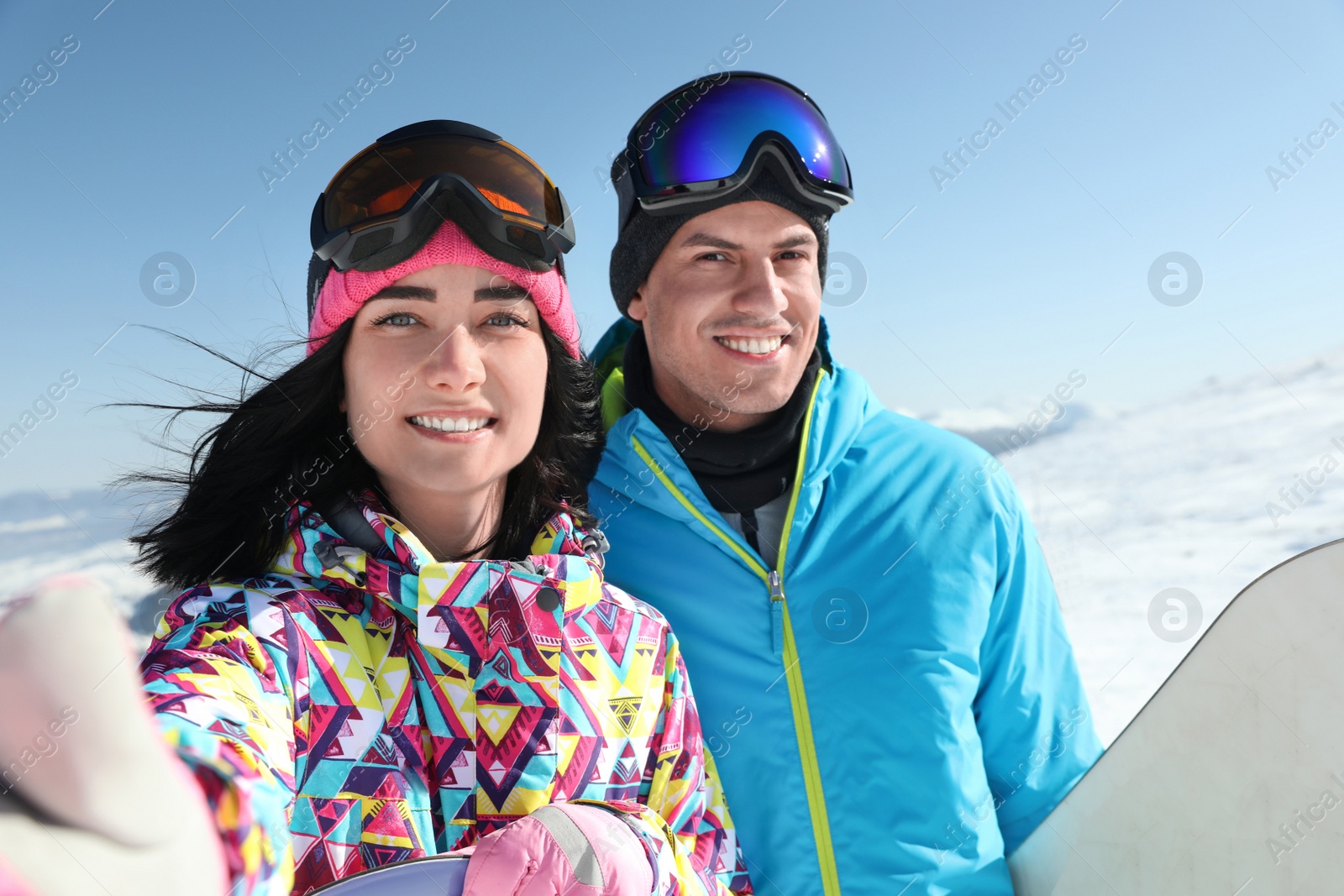 Photo of Happy couple with snowboards in mountains. Winter vacation